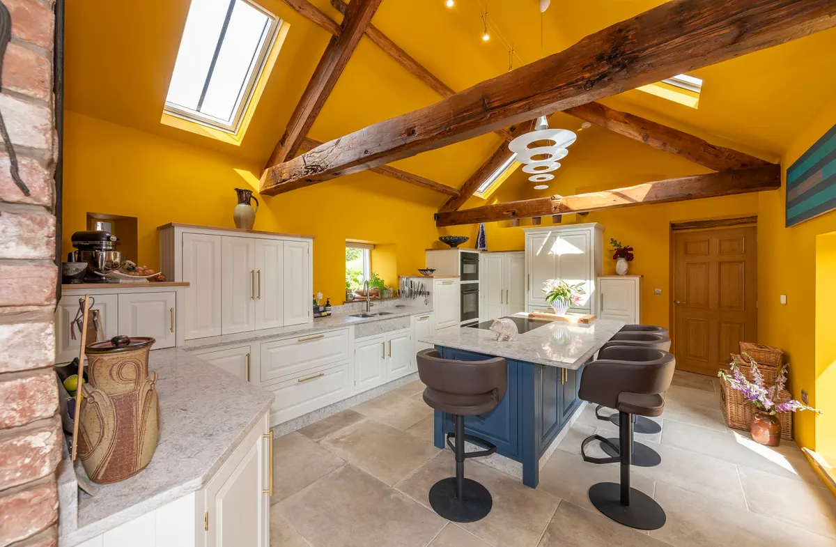 The Bassenthwaite barn kitchen from the roof-light end, roof trusses running the length of the room