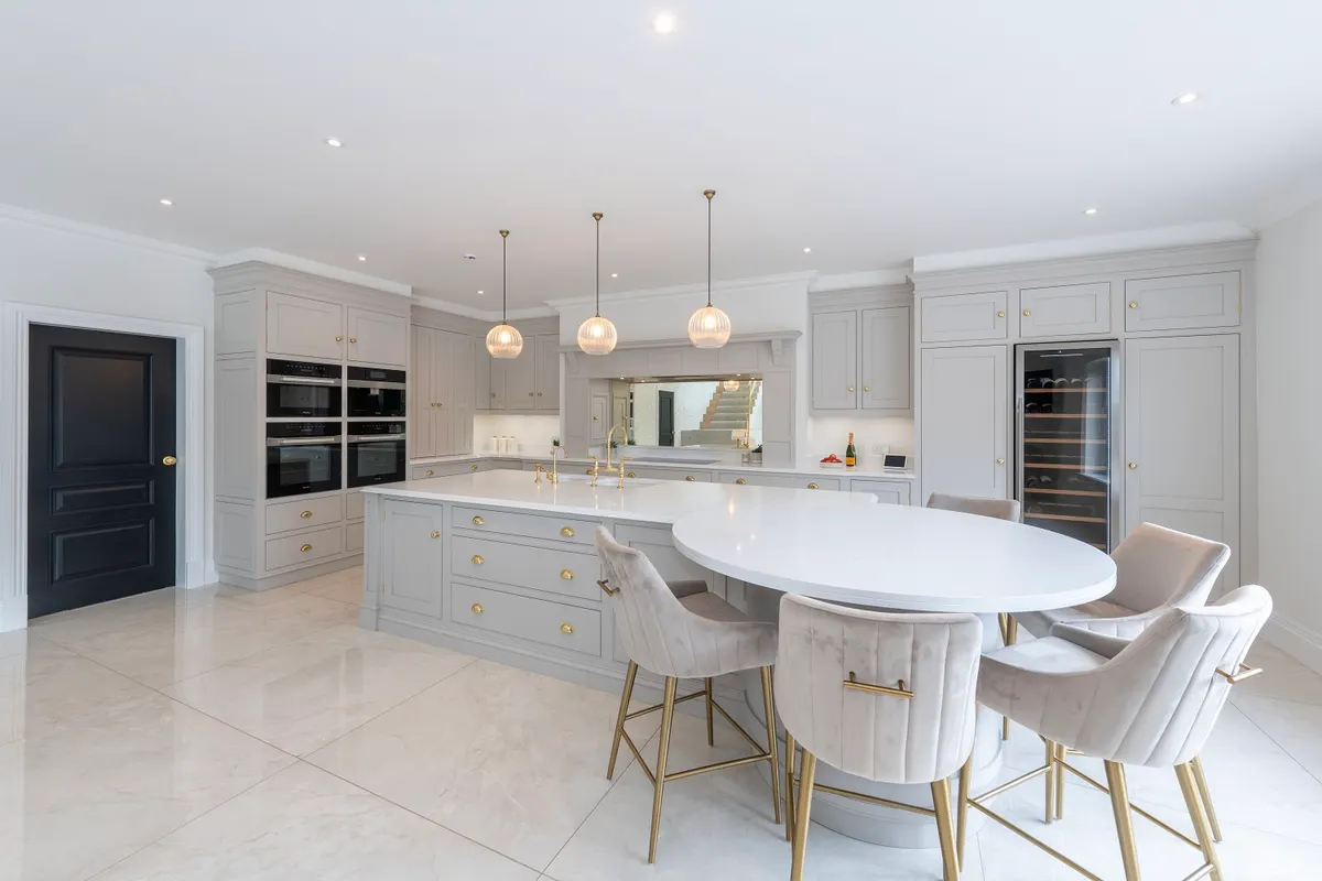 Contemporary kitchen at Dornock with a curved island and an oval breakfast table built into its end